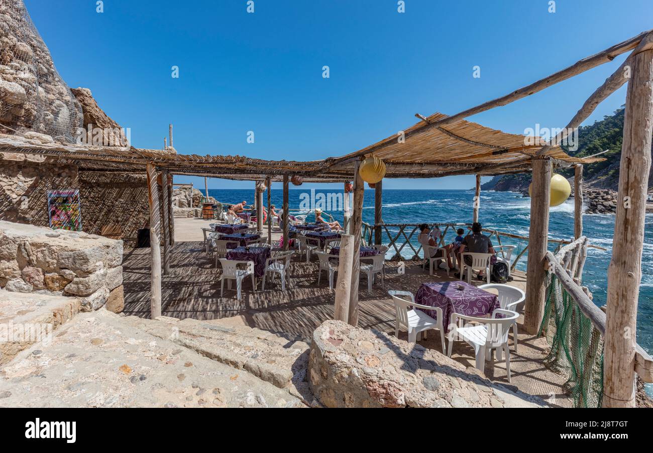 Cafe at Estellencs cove, beach (Cala Estellencs), Serra de Tramuntana UNESCO world heritage. Rocky location translucent aquamarine mediterranean Stock Photo