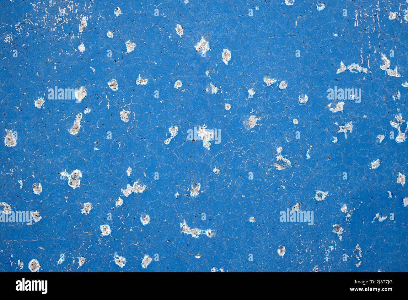 Blue concrete wall with traces of bullet shots. Background. Stock Photo