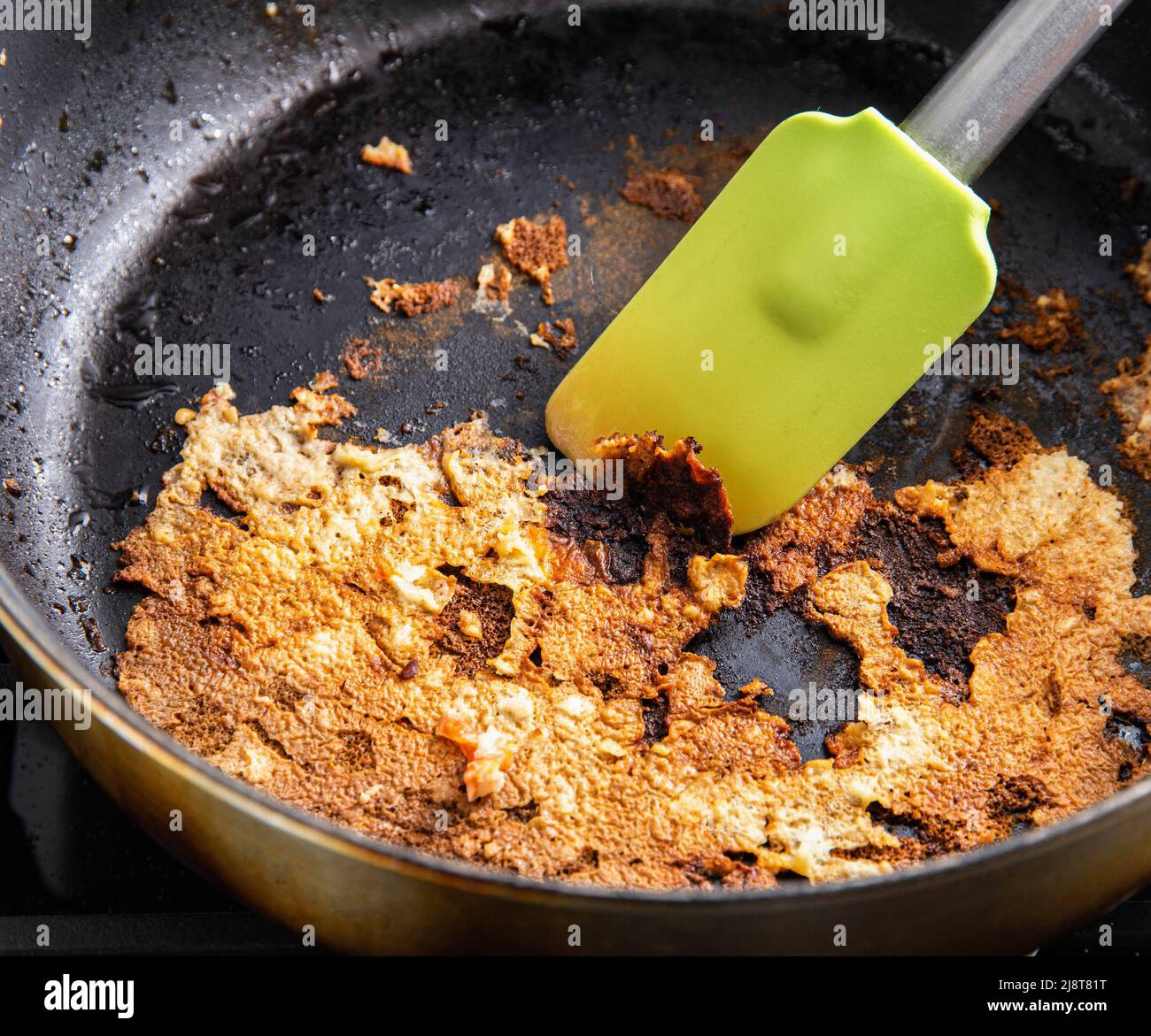 https://c8.alamy.com/comp/2J8T81T/a-spatula-for-stirring-food-picks-off-burnt-food-in-a-pan-poor-quality-teflon-coated-pans-2J8T81T.jpg