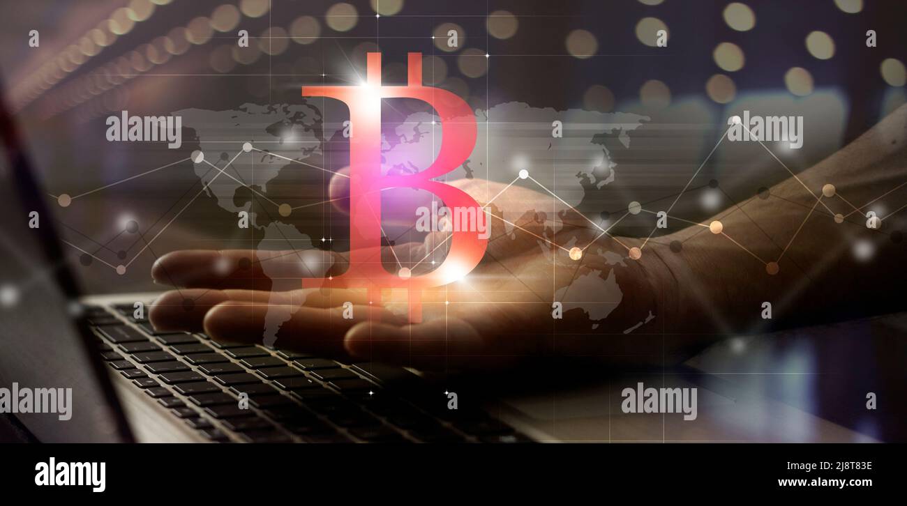 bitcoin in hand in front of laptop. concept web technology business background. trading, saving and investing. mixed media banner Stock Photo