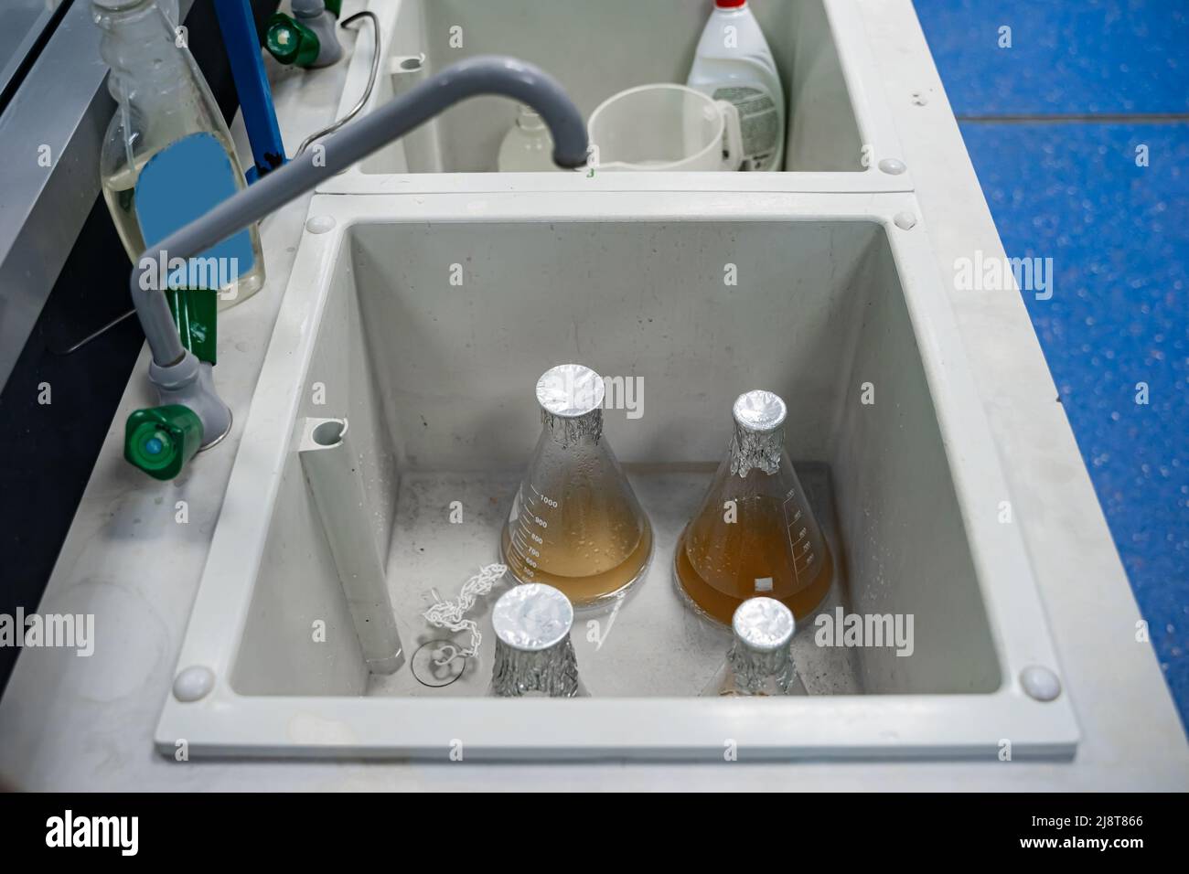 Large flasks with residual chemical materials stand in the sink. Dirty or contaminated laboratory glassware Stock Photo