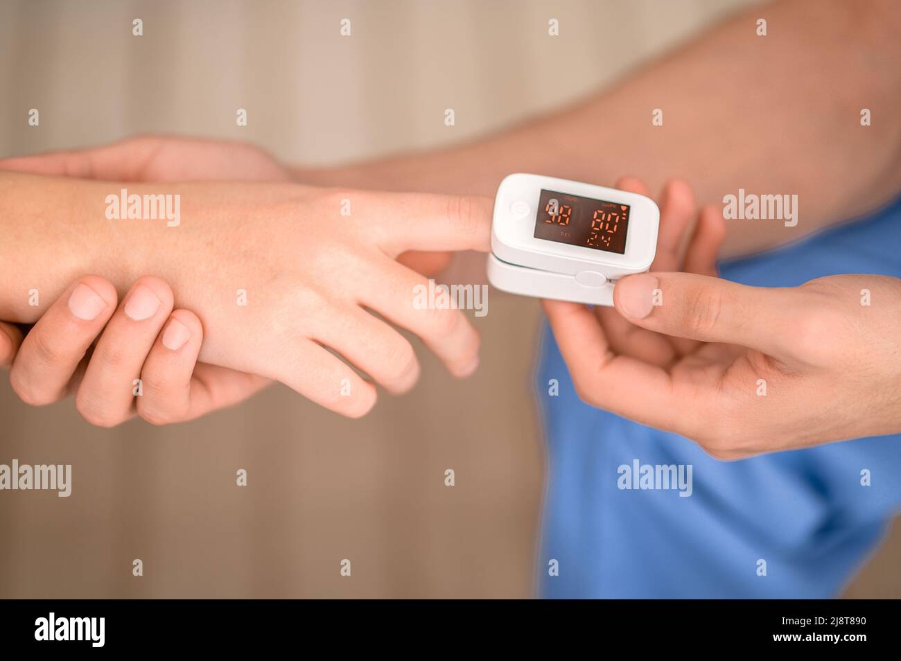 Experienced doctor measuring the oxygen saturation in the blood Stock Photo