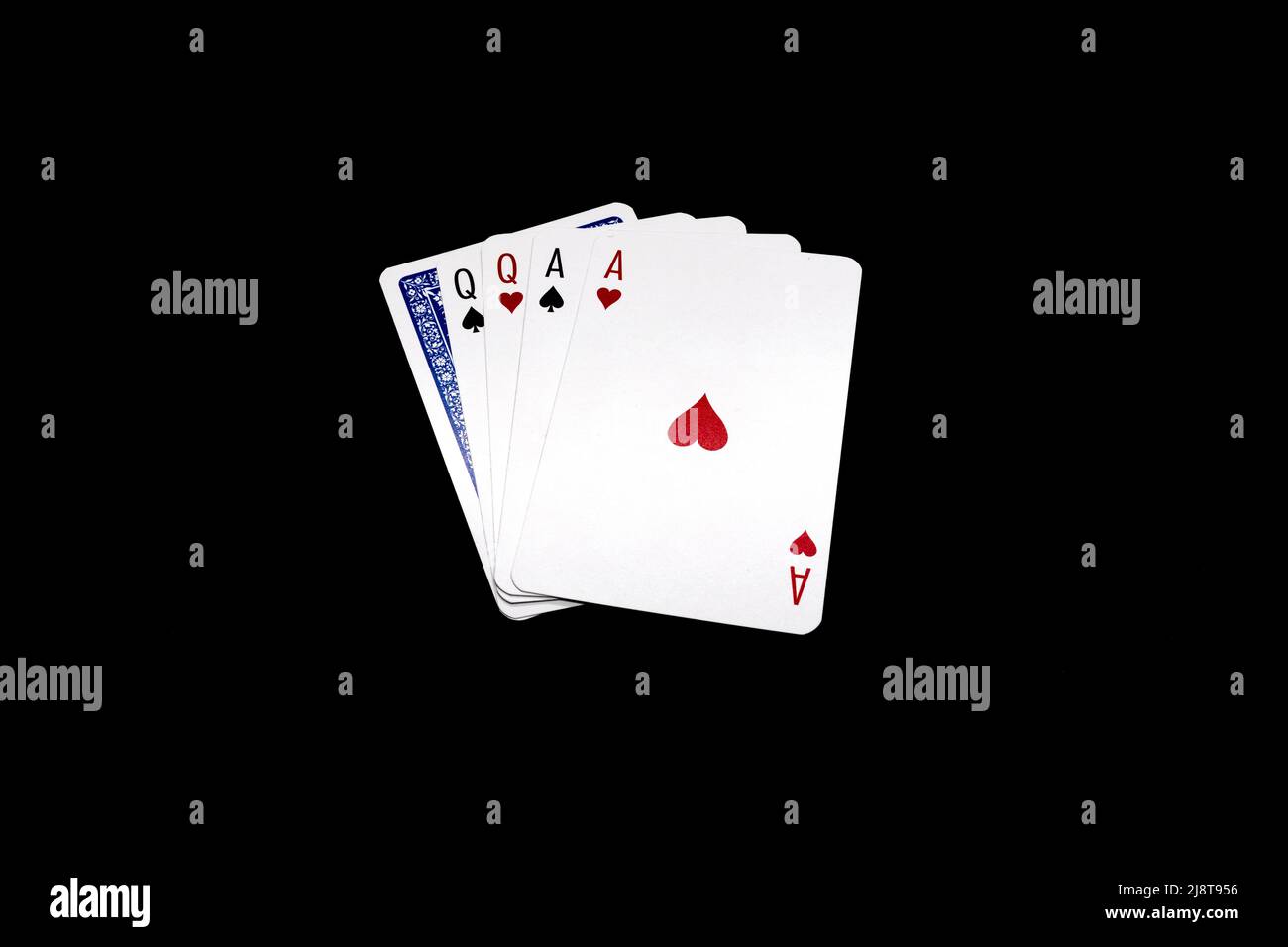 Two pair of queens and aces  with one overturned card.  Poker hand isolated on black background Stock Photo