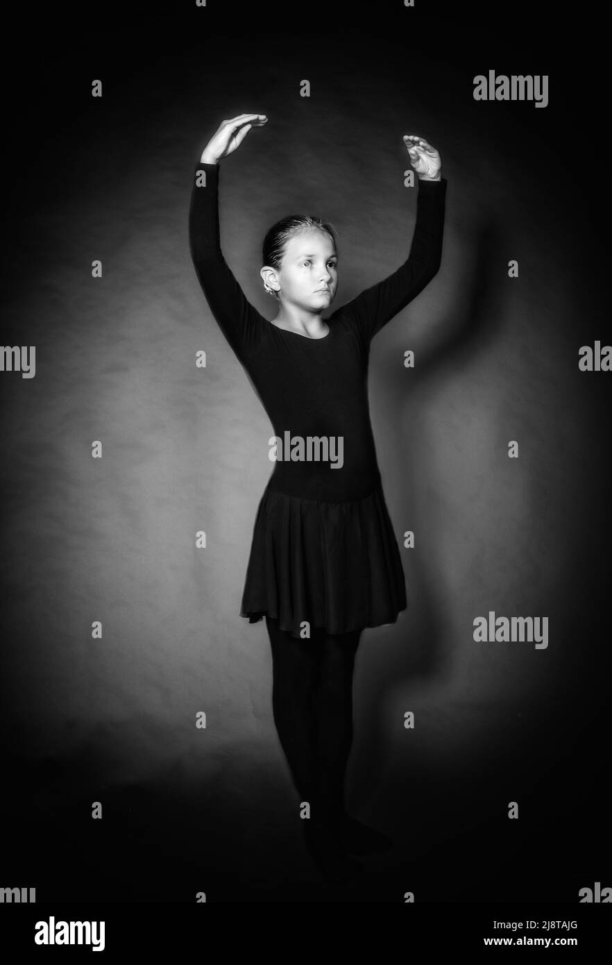 Young girl in dance clothes stands in position in monochrome Stock Photo