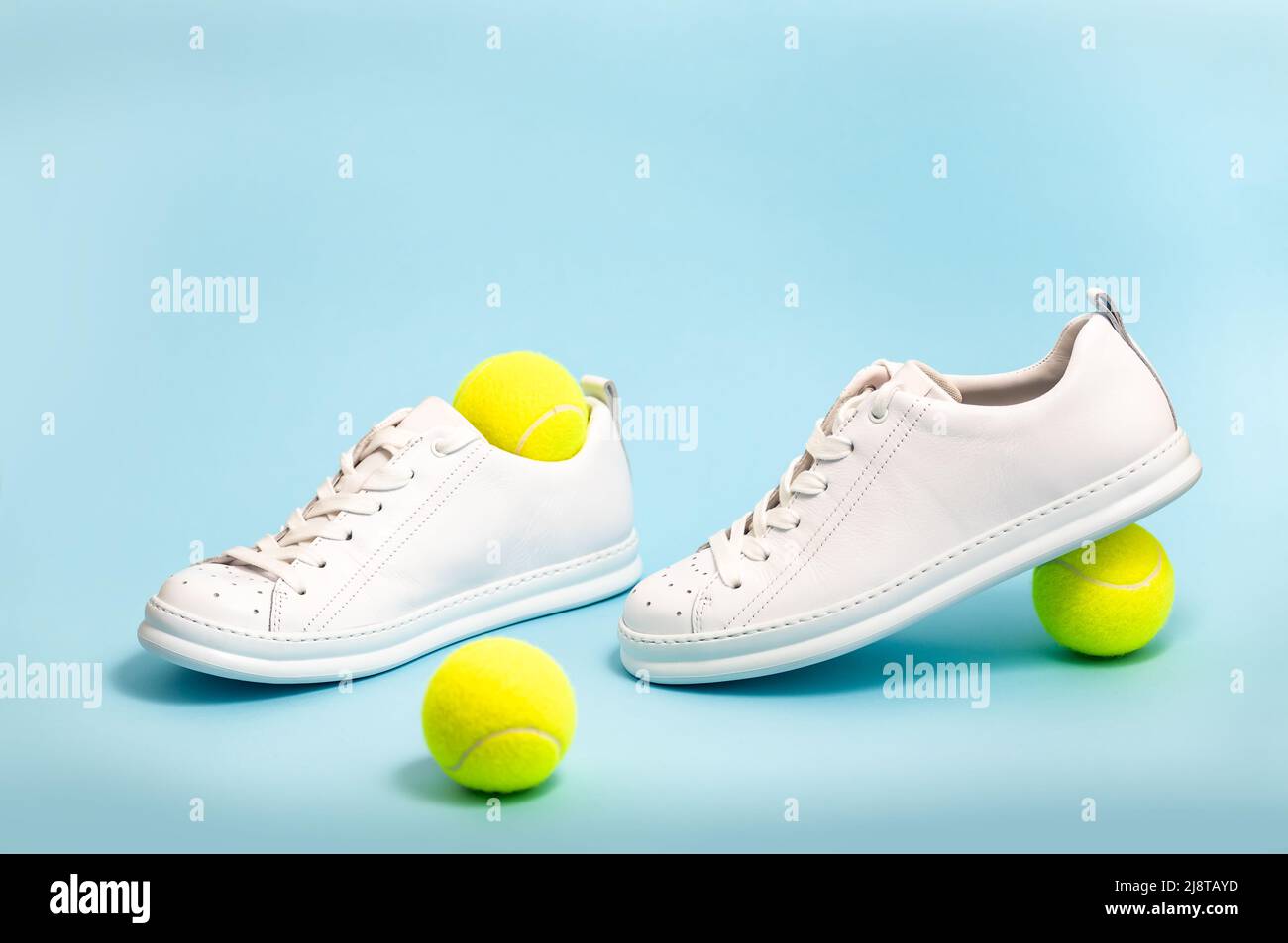 New unbranded fancy white tennis shoes on blue background New unbranded Sneakers or trainers on blue background. Men's sport footwear Stock Photo