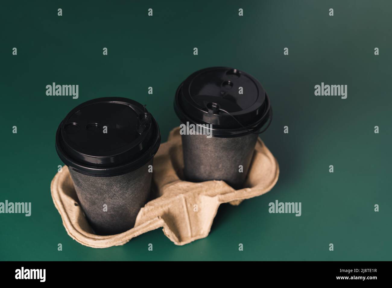 Disposable cups on stand against green background Stock Photo