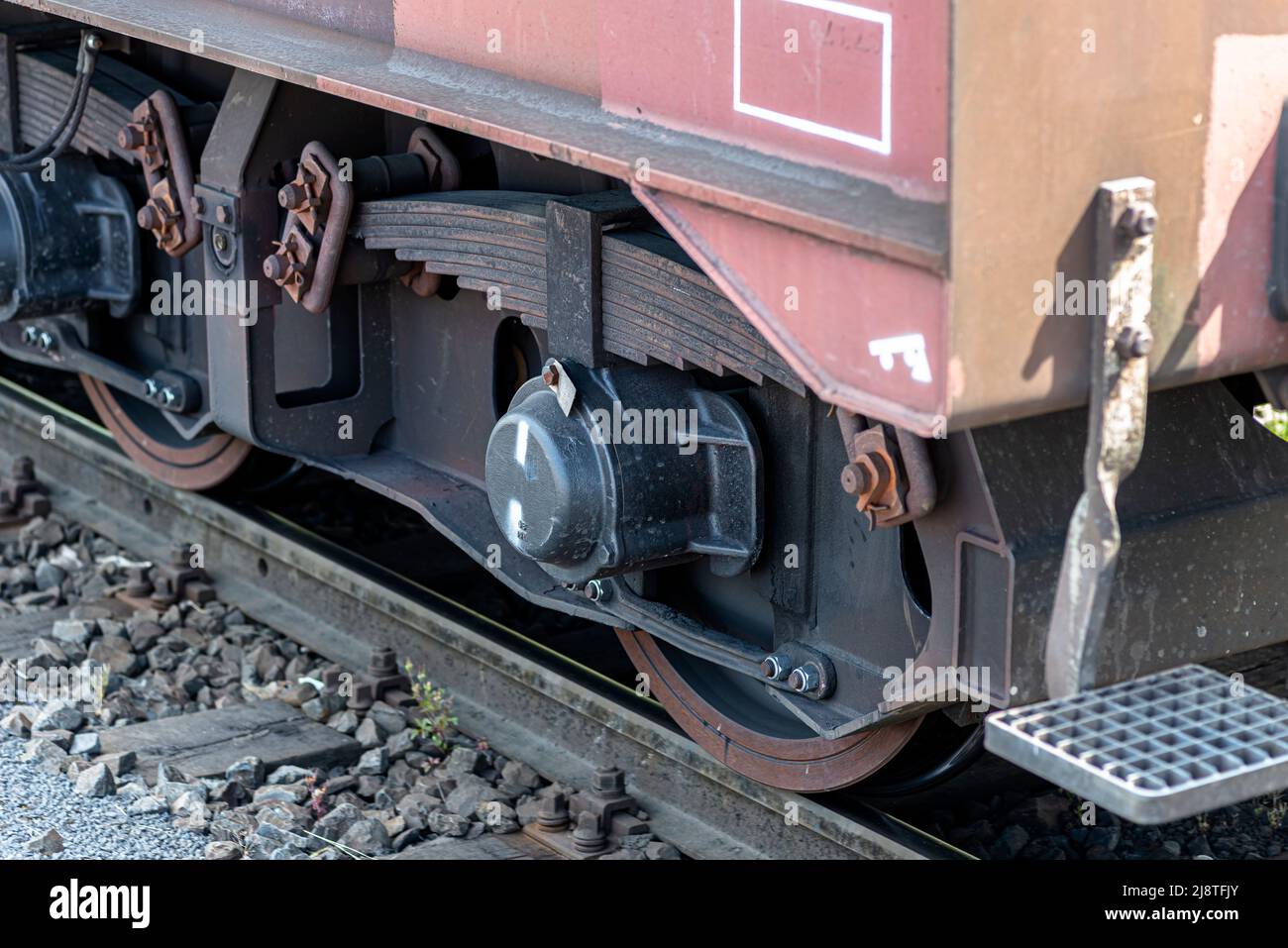 Steel wheels of a freight car running on rails, visible semielliptical