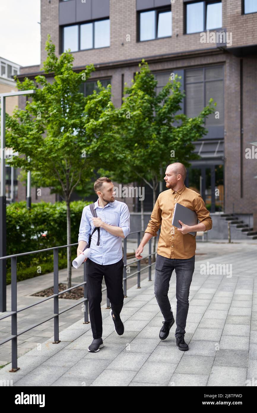 Real estate managers or financial business team talking outdoor modern building background. On the go meeting in downtown near office. Construction, architecture specialist concept. High quality image Stock Photo