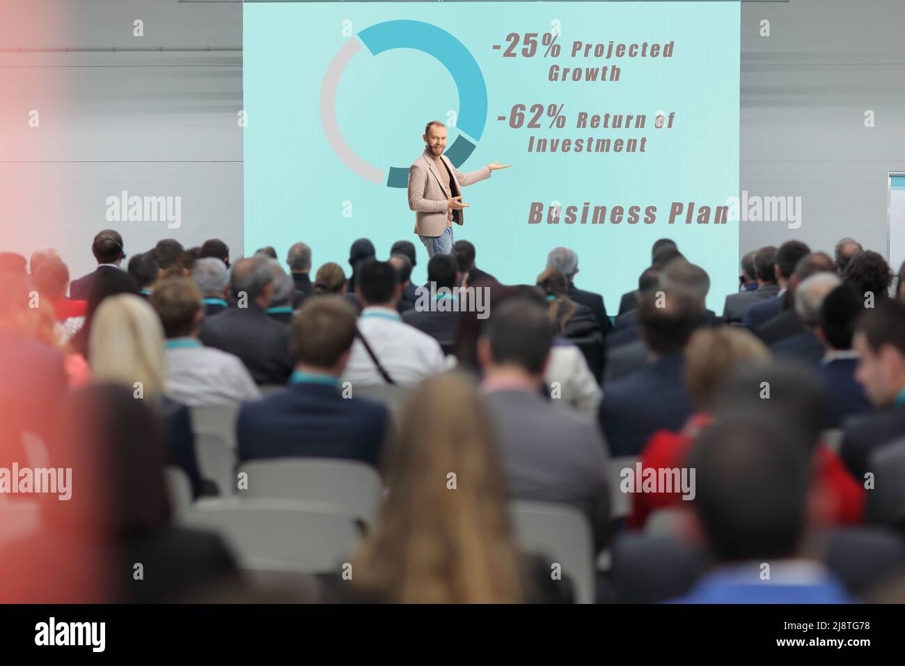 People in the audience and man presenting a business plan at a business conference Stock Photo