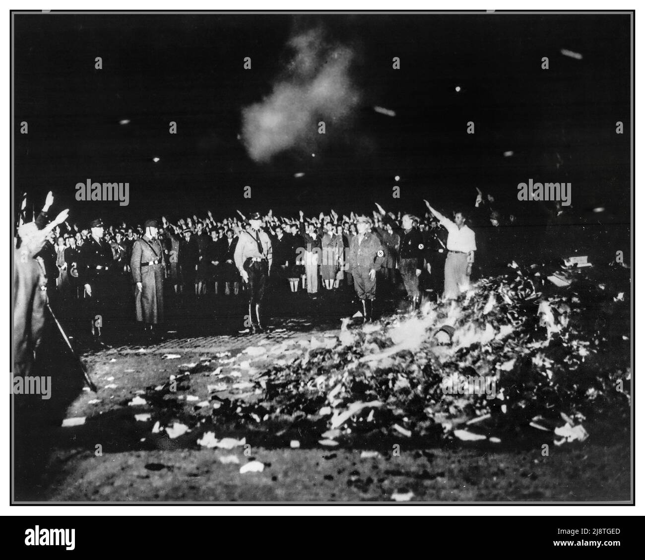 NAZI BOOK BURNING CENSORSHIP 1933 Thousands of books smoulder in a huge bonfire as Germans give the Nazi salute during the wave of book-burnings that spread throughout Nazi Germany in the 1930s Book burning--Germany--1930-1940 Nazis--Germany--1930-1940 World War II--United States War posters--United States--1940-1950 Stock Photo