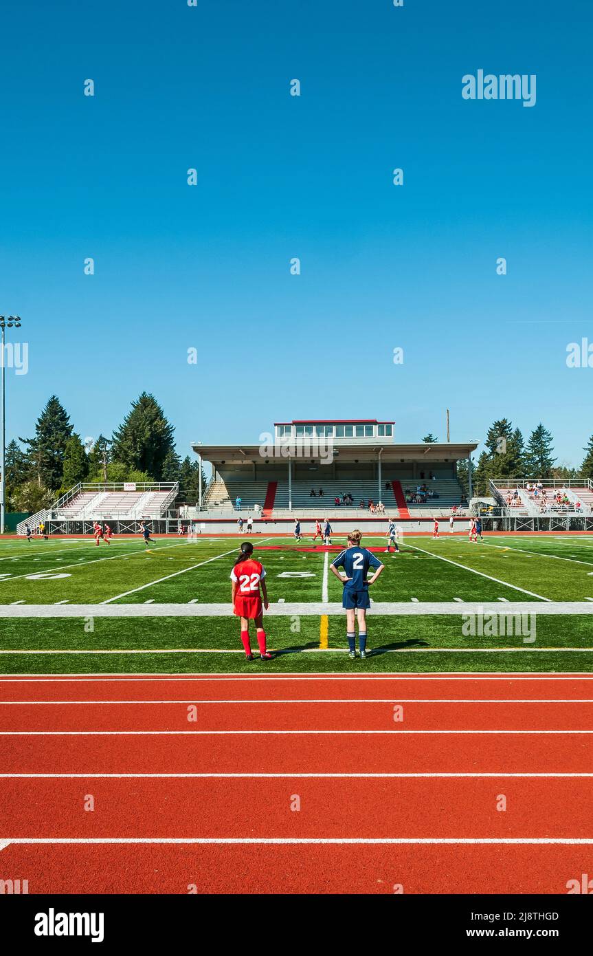 Girls' soccer players on the football/soccer field and side lines at David Douglas High School