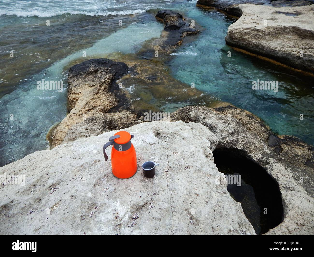 Orange thermos on the shore of the Caspian Sea. Kazakhstan. Mangistau region. 15 July. 2020 year. Stock Photo