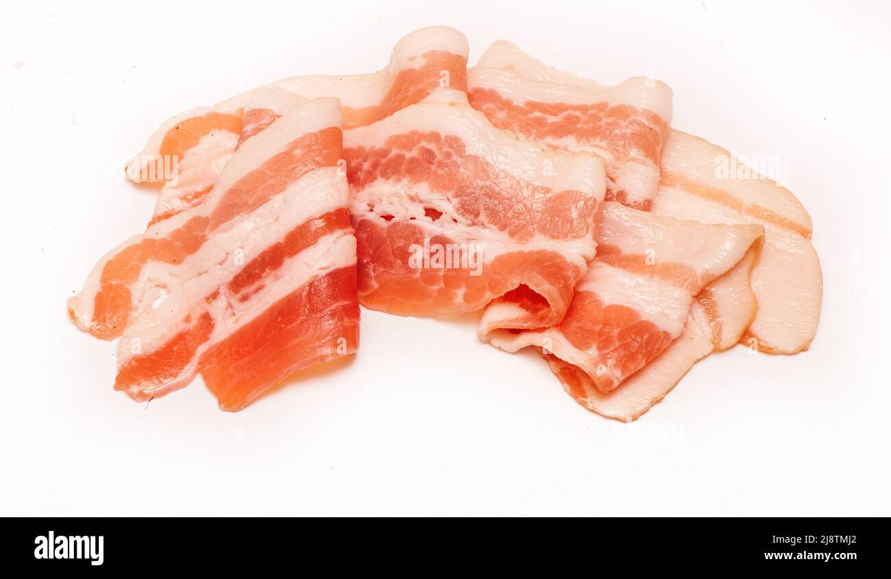 Several pieces of bacon cut into strips on a white background Stock Photo