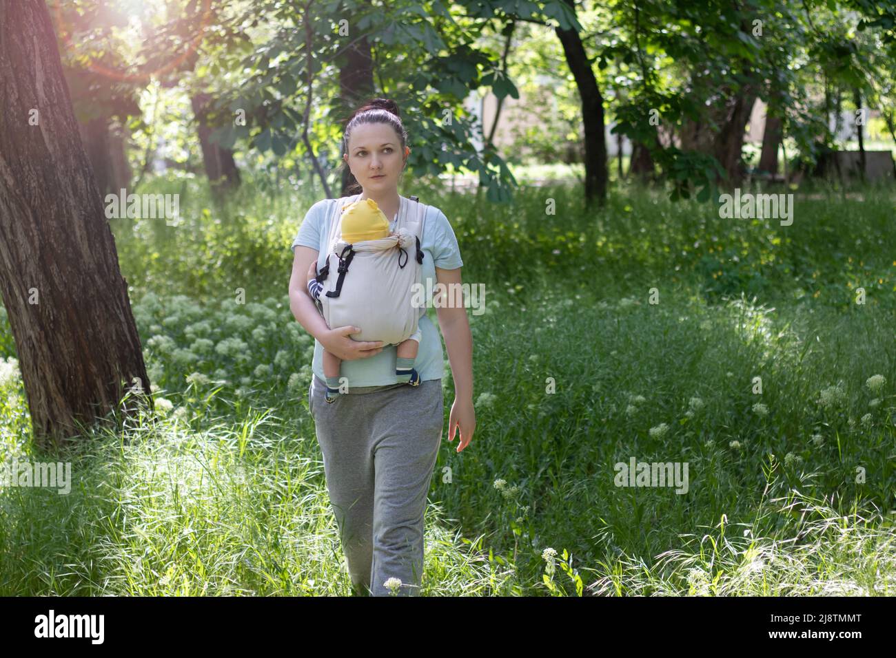 mother carrying her baby in sling outdoor Stock Photo