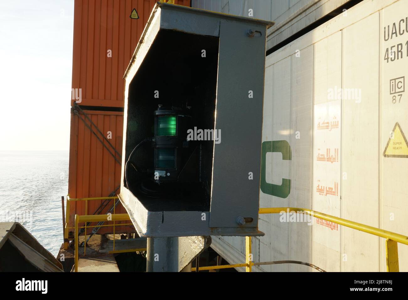 Green starboard side navigational lights of the loaded container ship