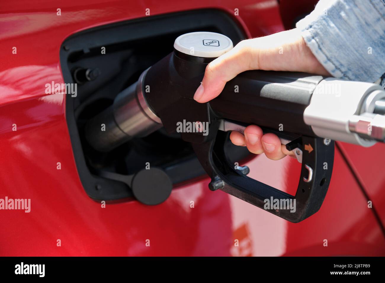woman hand fueling car with Compressed Natural Gas (CNG) Stock Photo