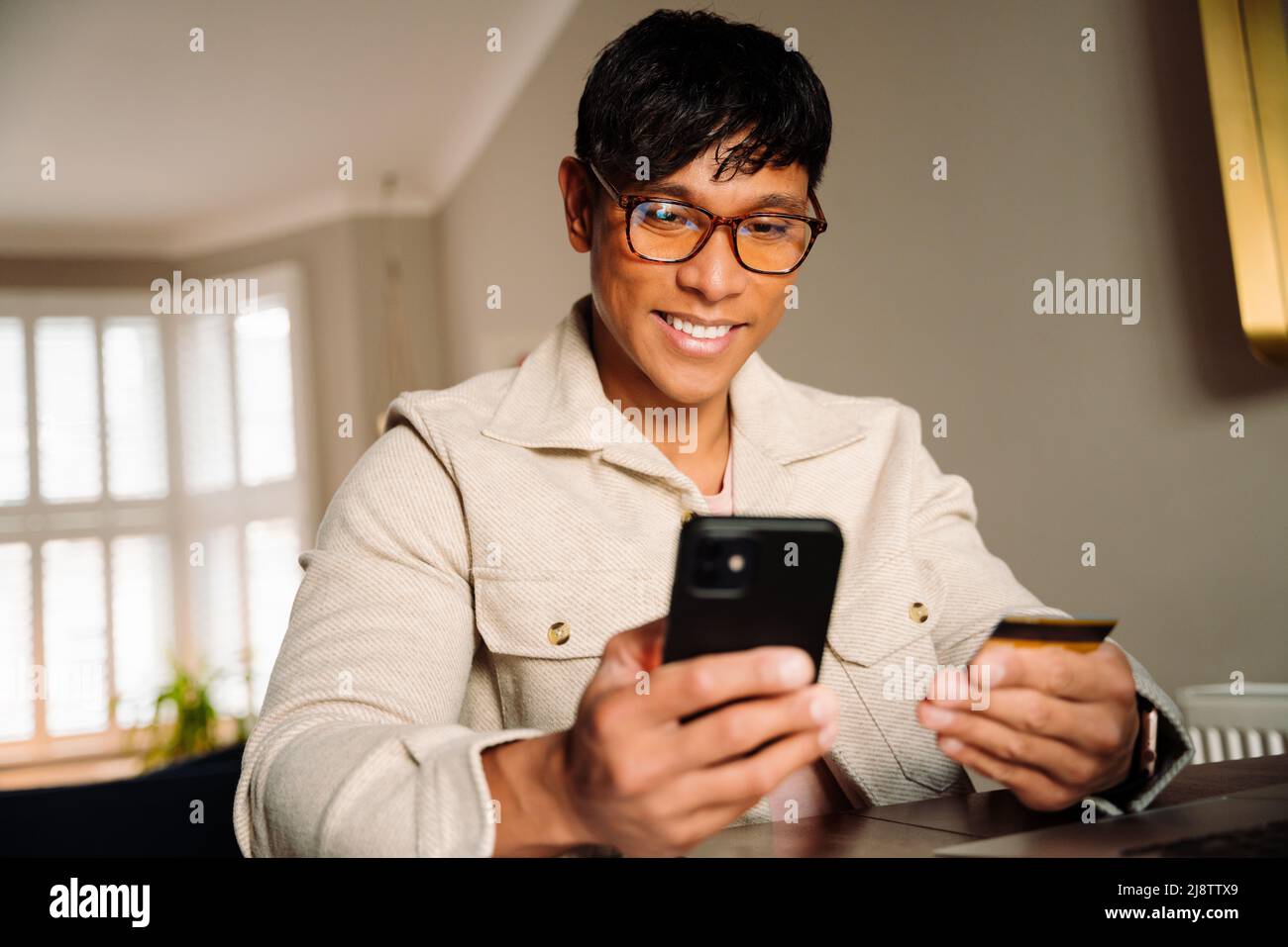 Asian male making payment on cellphone Stock Photo