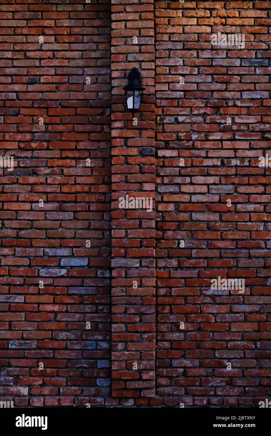 Street lamp on red, old brick wall Stock Photo
