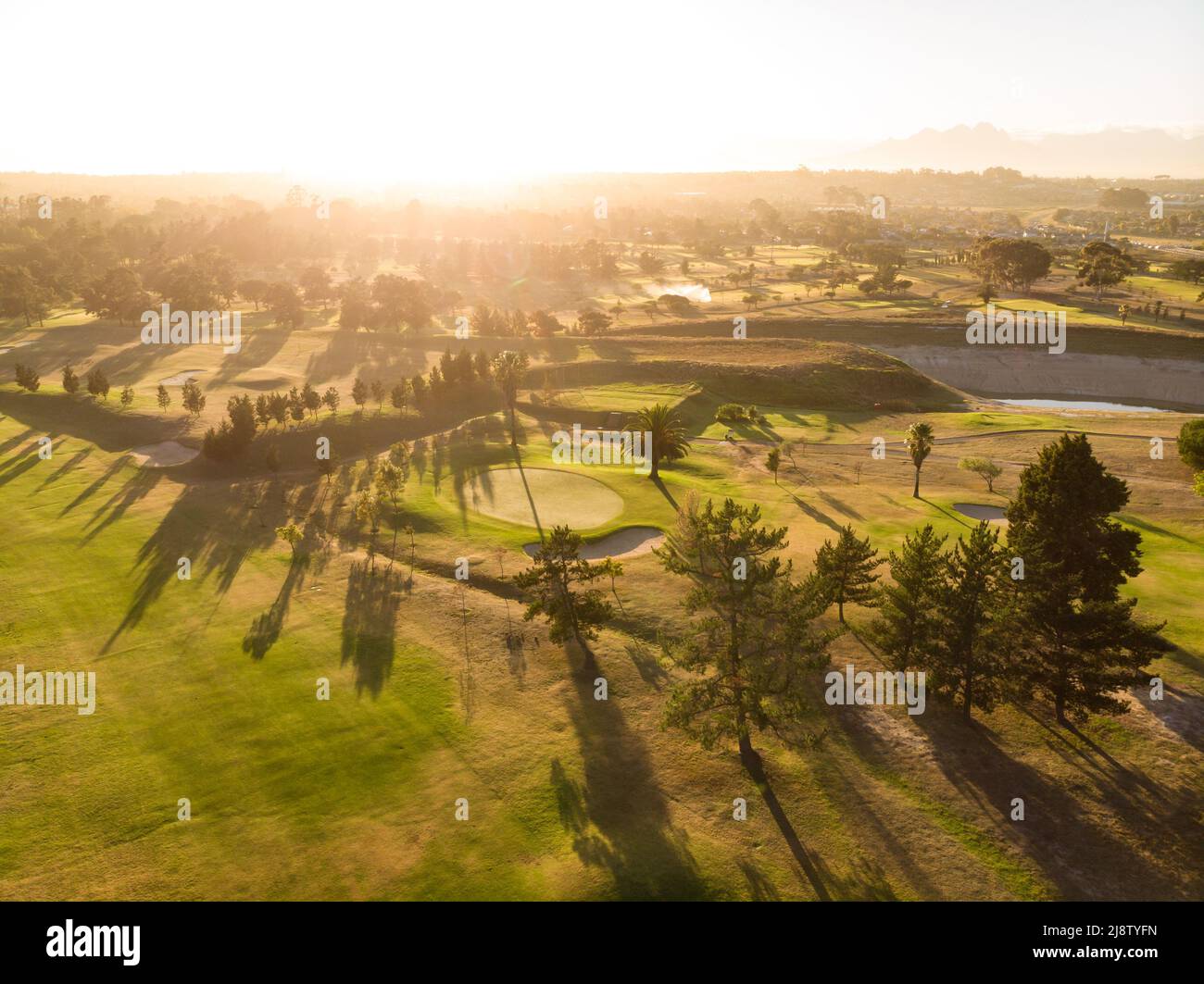 Aerial scenic view of lush landscape and bright sun against clear sky during sunset, copy space Stock Photo