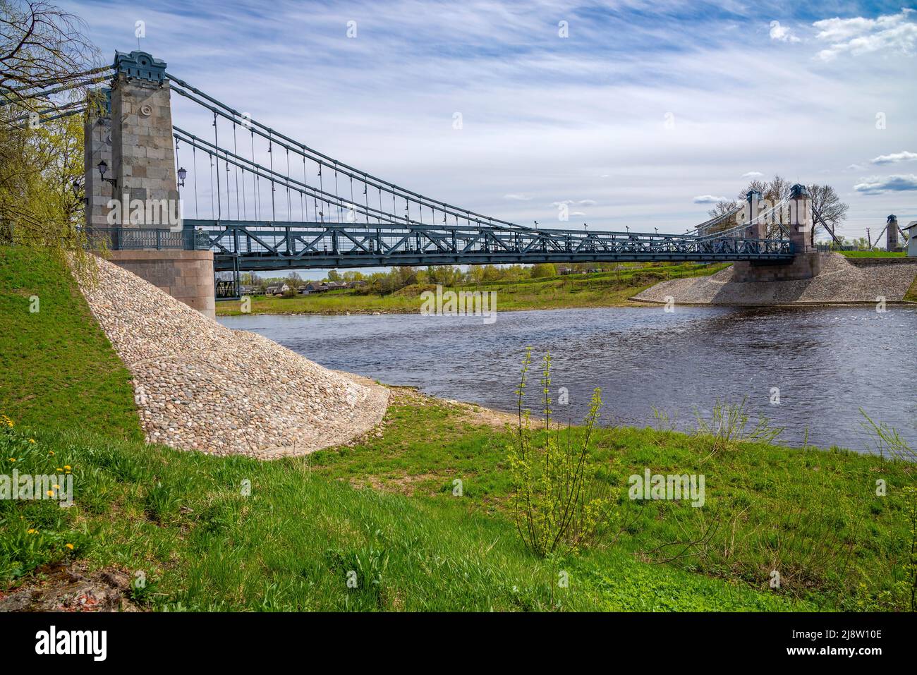 An ancient suspended chain bridge on the Velikaya River. The city of Ostrov, Pskov region. Russia Stock Photo