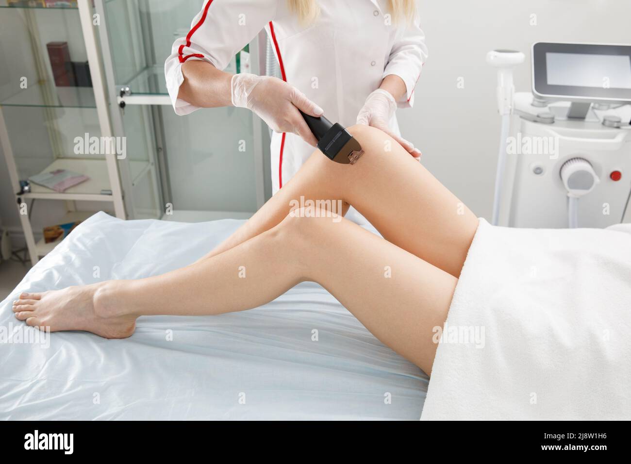 A woman undergoes an anti-cellulite procedure in a cosmetology clinic. Stock Photo