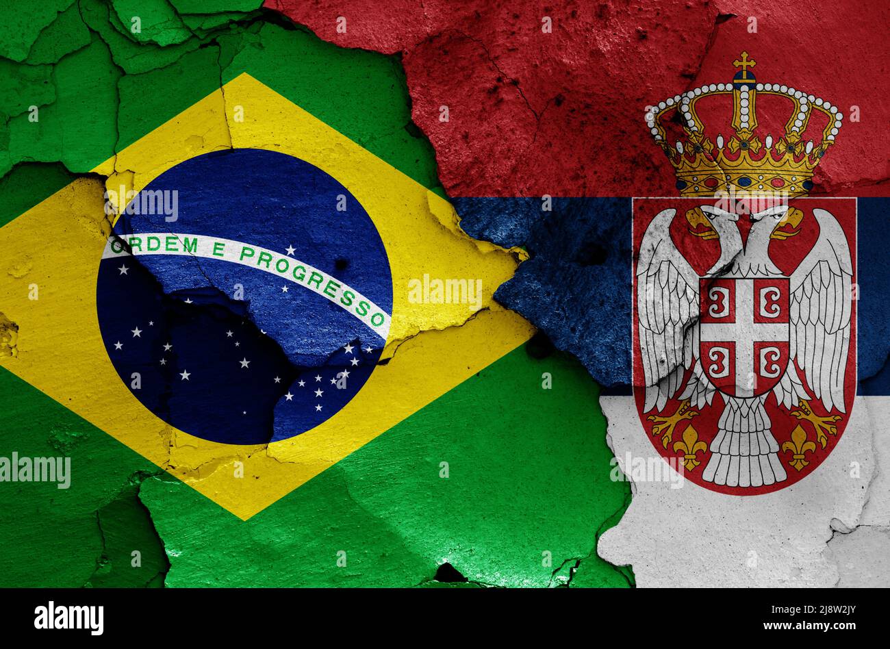 flags of Brazil and Serbia painted on cracked wall Stock Photo
