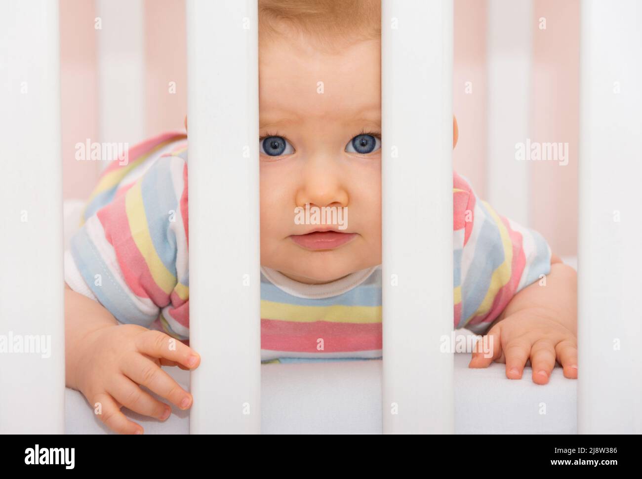 Toddler looks out of his cot Stock Photo Alamy