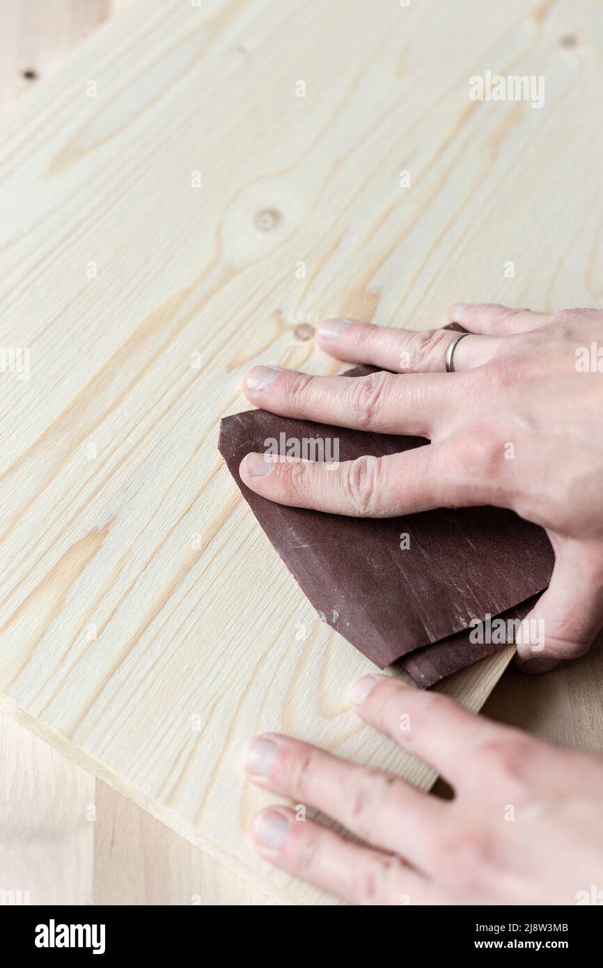 Sanding boards by hand. Sanding with abrasive paper Stock Photo Alamy