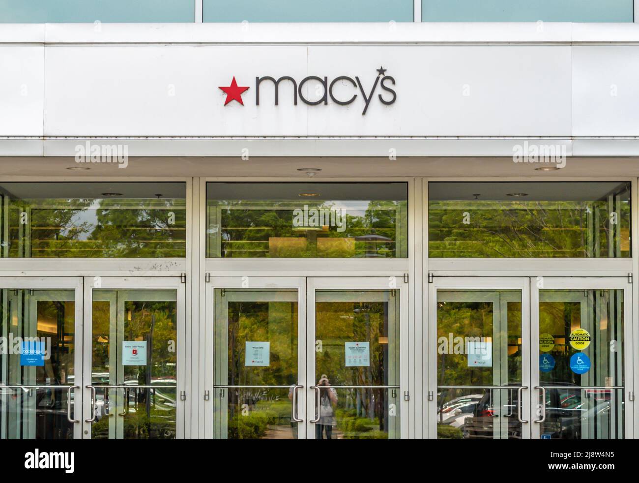 Outdoor facade brand and logo signage above reflective glass doors and ...