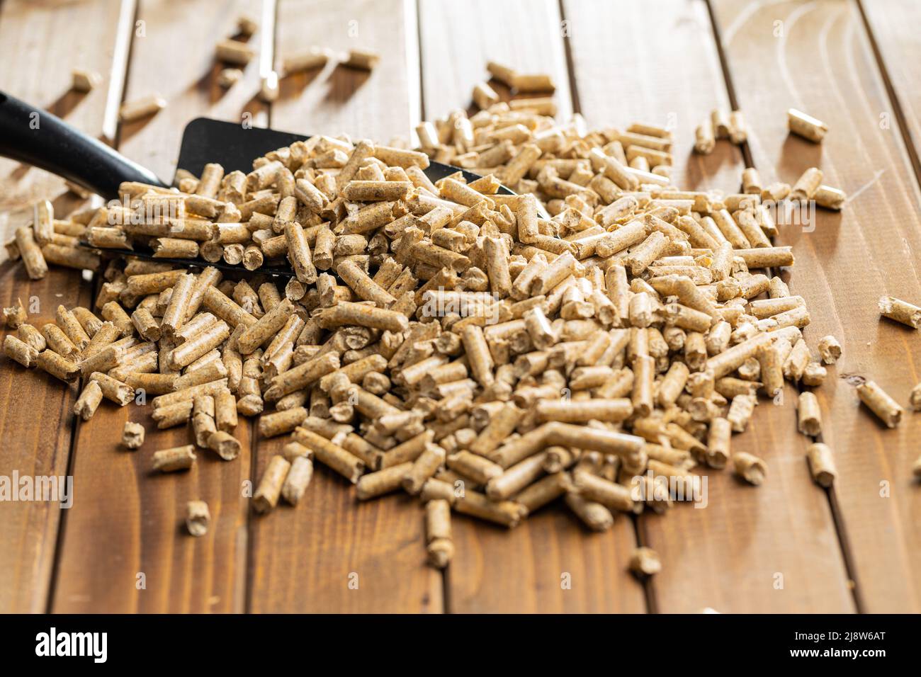 Wooden pellets, biofuel on wooden table. Ecologic fuel made from biomass. Renewable energy source on wooden table. Stock Photo