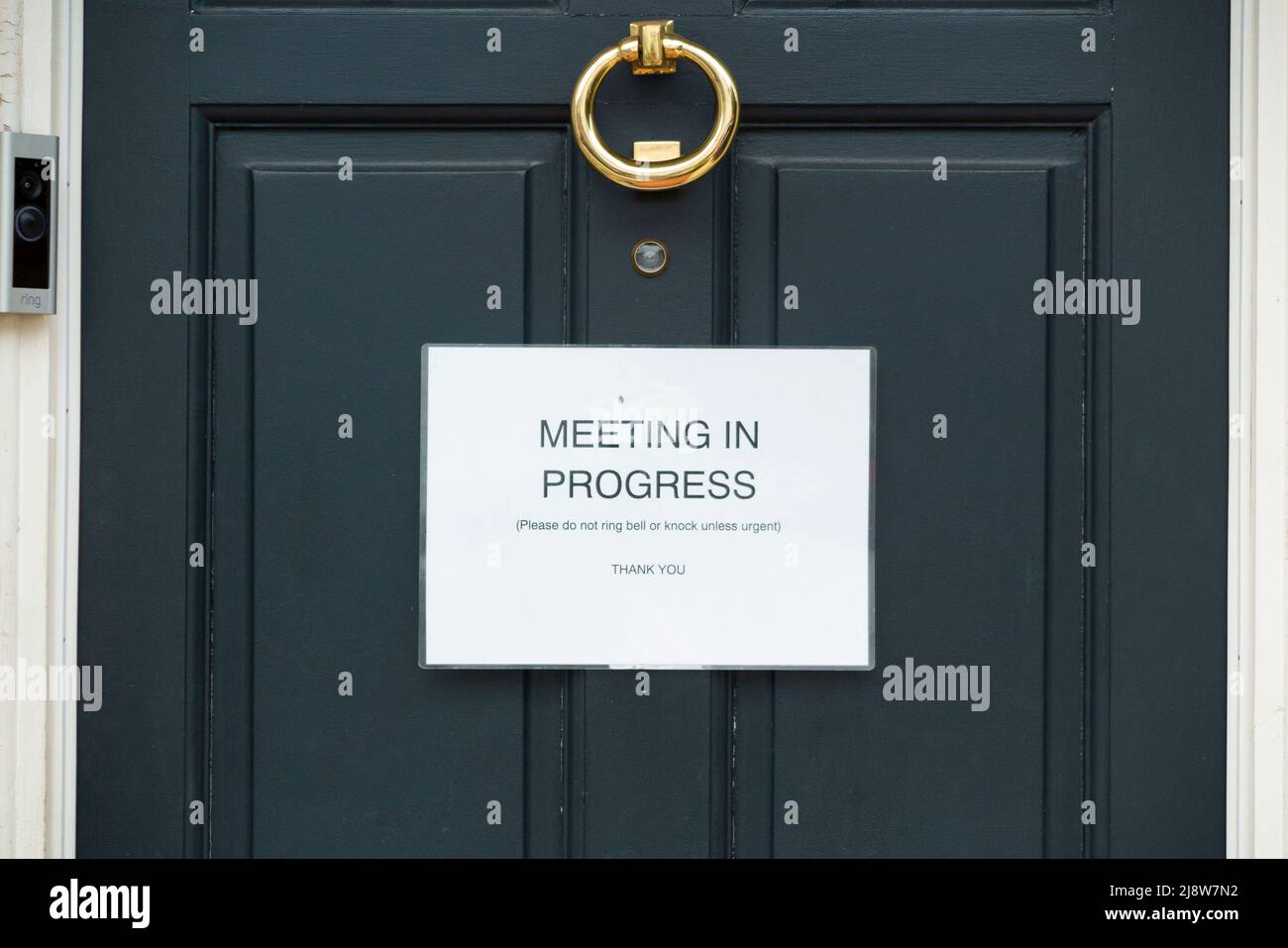 Meeting in progress sign attached to a domestic house front door presumably where somebody is Working From Home WFH or in a hybrid job. UK (130) Stock Photo