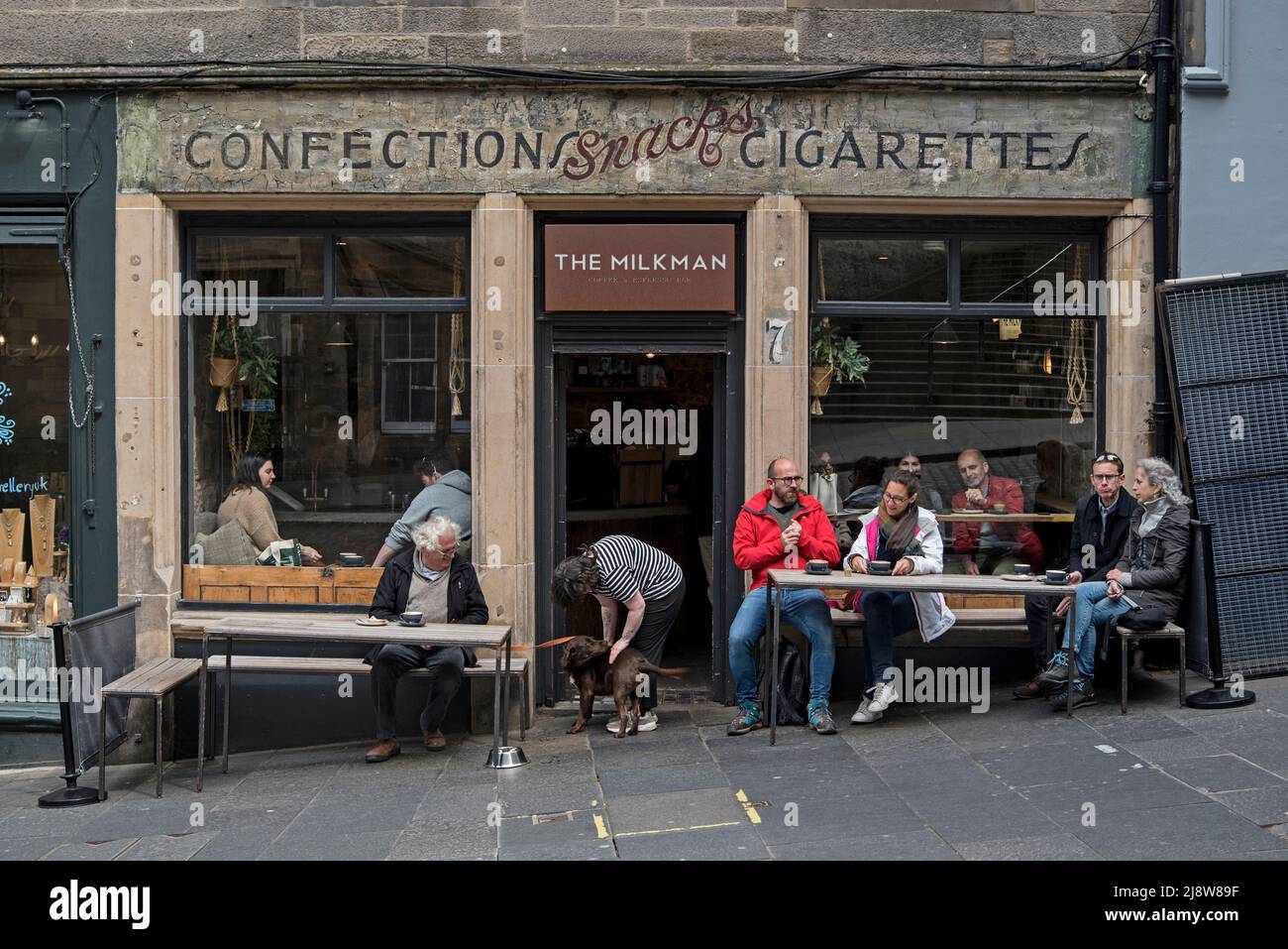 The Milkman, a coffee shop on Cockburn Street in Edinburgh with the original 'Confections Snacks Cigarettes' sign painted on the wall. Stock Photo