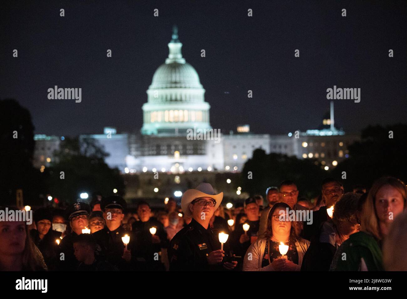Washington, United States of America. 13 May, 2022. Members of law enforcement and families hold candles during the 34th Annual Candlelight Vigil, an event honoring fallen law enforcement officers at the the National Peace Officers Memorial on the West Front of the U.S. Capitol, May 13, 2022 in Washington, D.C.  Credit: Shane T. McCoy/U.S. Marshalls Office/Alamy Live News Stock Photo