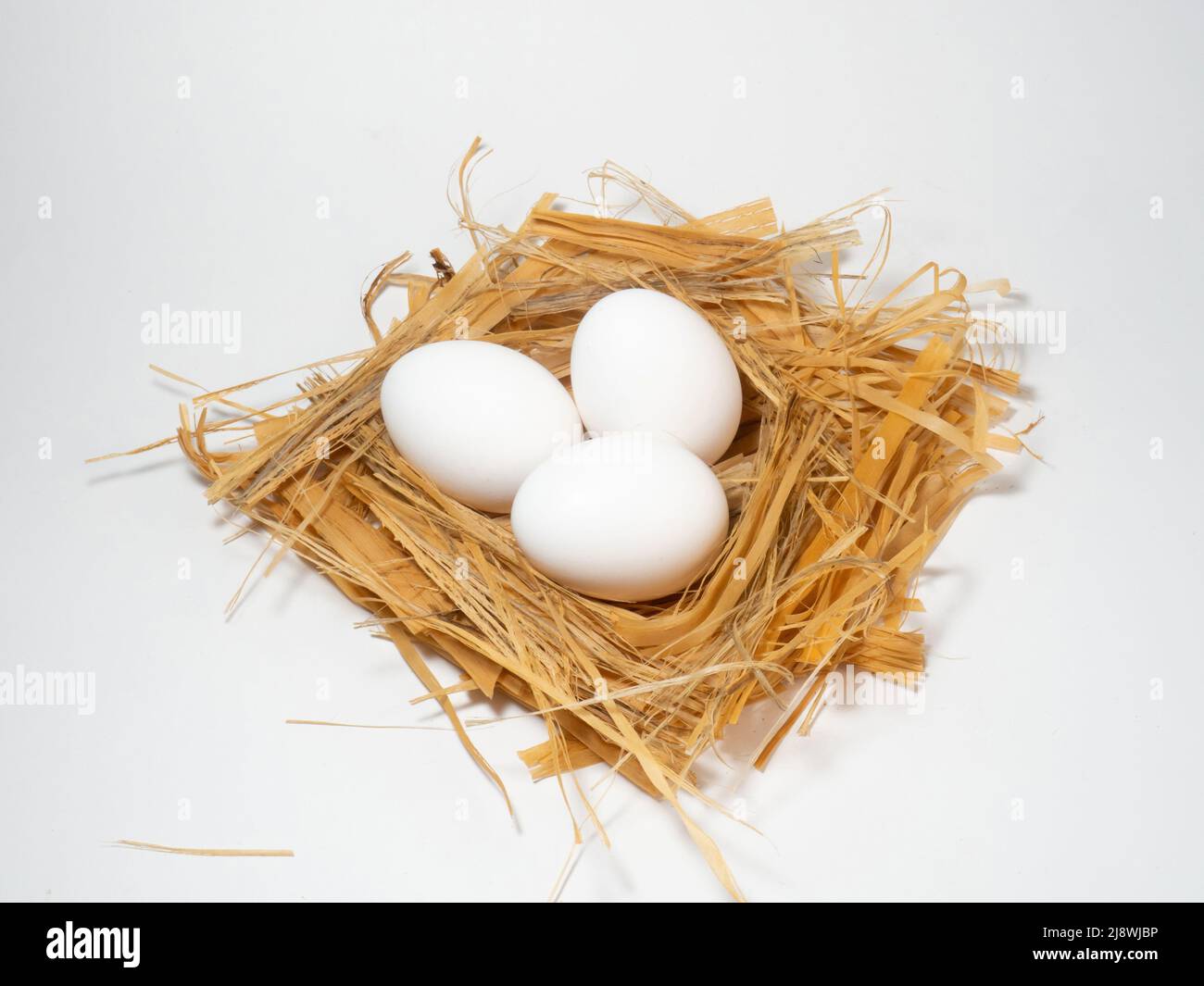 A chicken egg lies in the straw. Three eggs Stock Photo - Alamy