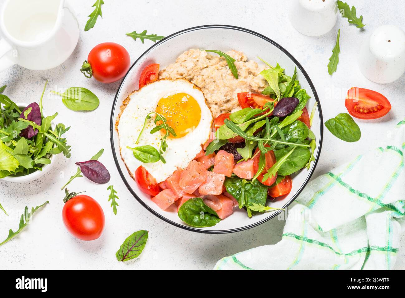 Savory breakfast with oatmeal, salmon and salad. Stock Photo