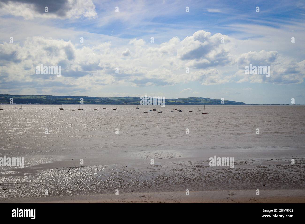 View of the North Wales coast from West Kirby, with sail boast on the River Dee Estuary Stock Photo