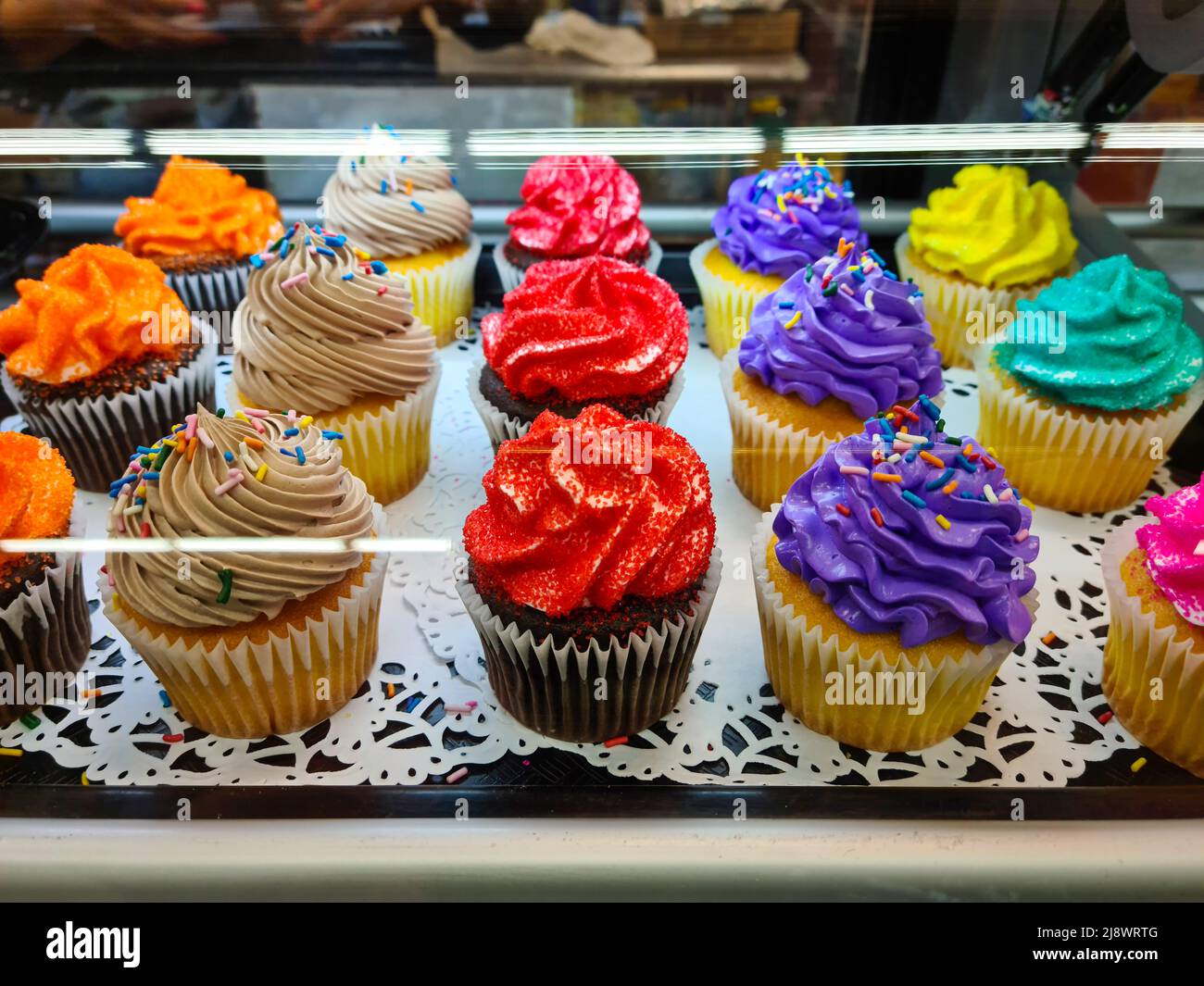 confectionery showcase with cupcake assorted flavors Stock Photo Alamy