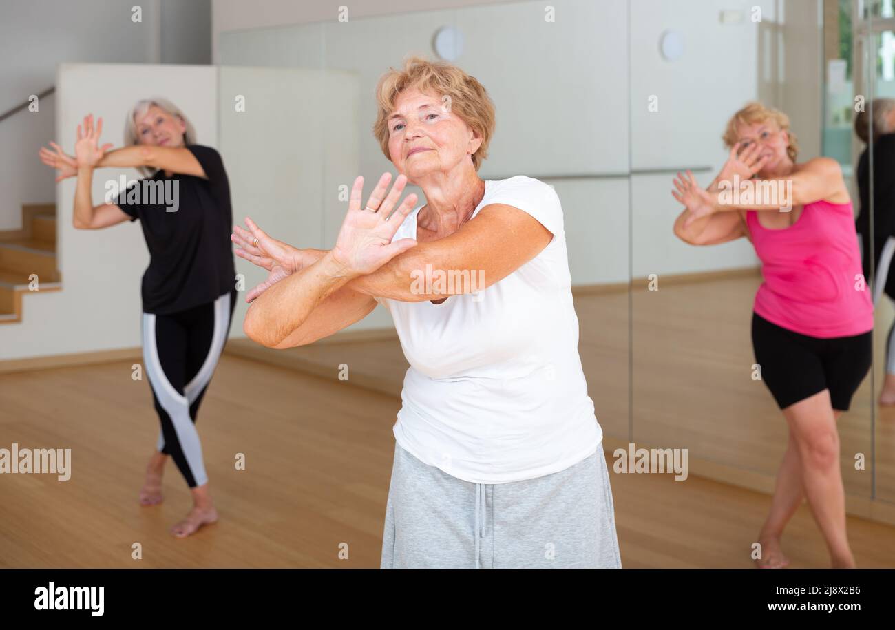 Active elderly lady learning modern dynamic dances in choreography class Stock Photo