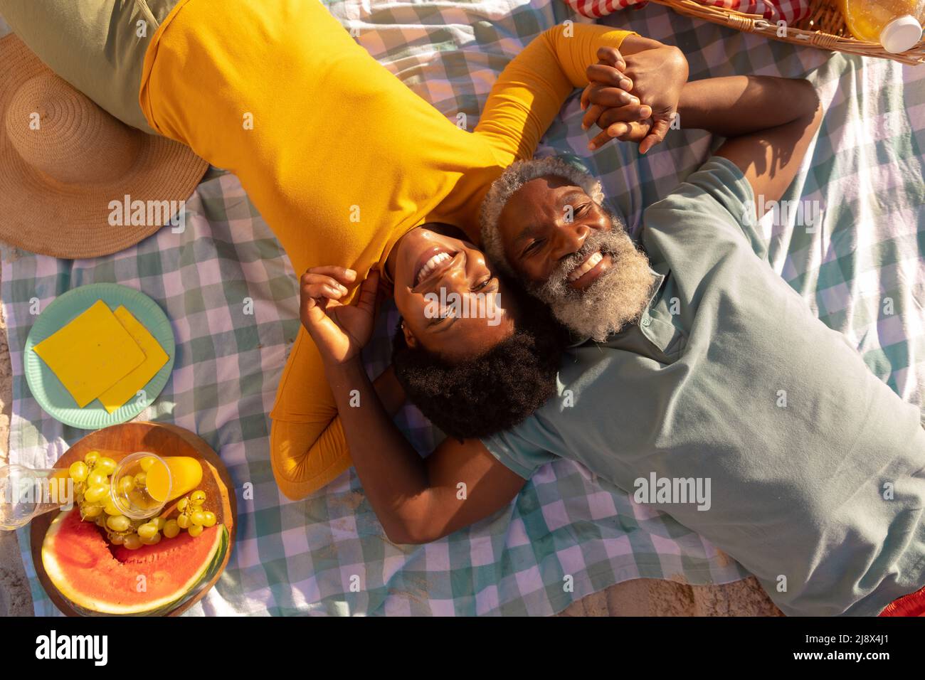 Overhead view of happy african american couple holding hands by food ...