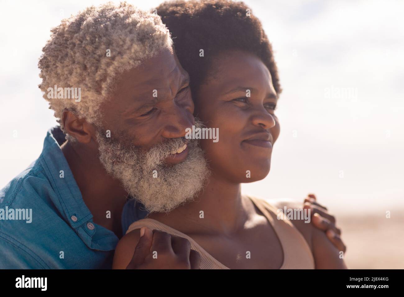 Close-up of smiling bearded african american senior man and mature woman with afro hair looking away Stock Photo
