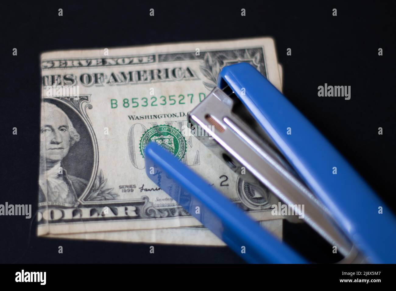 An effort to fix a worn-out dollar with a stapler Stock Photo