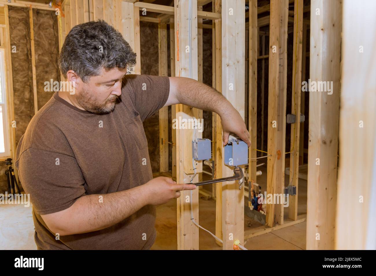 Work on installing electrical outlets mounts in new home Stock Photo