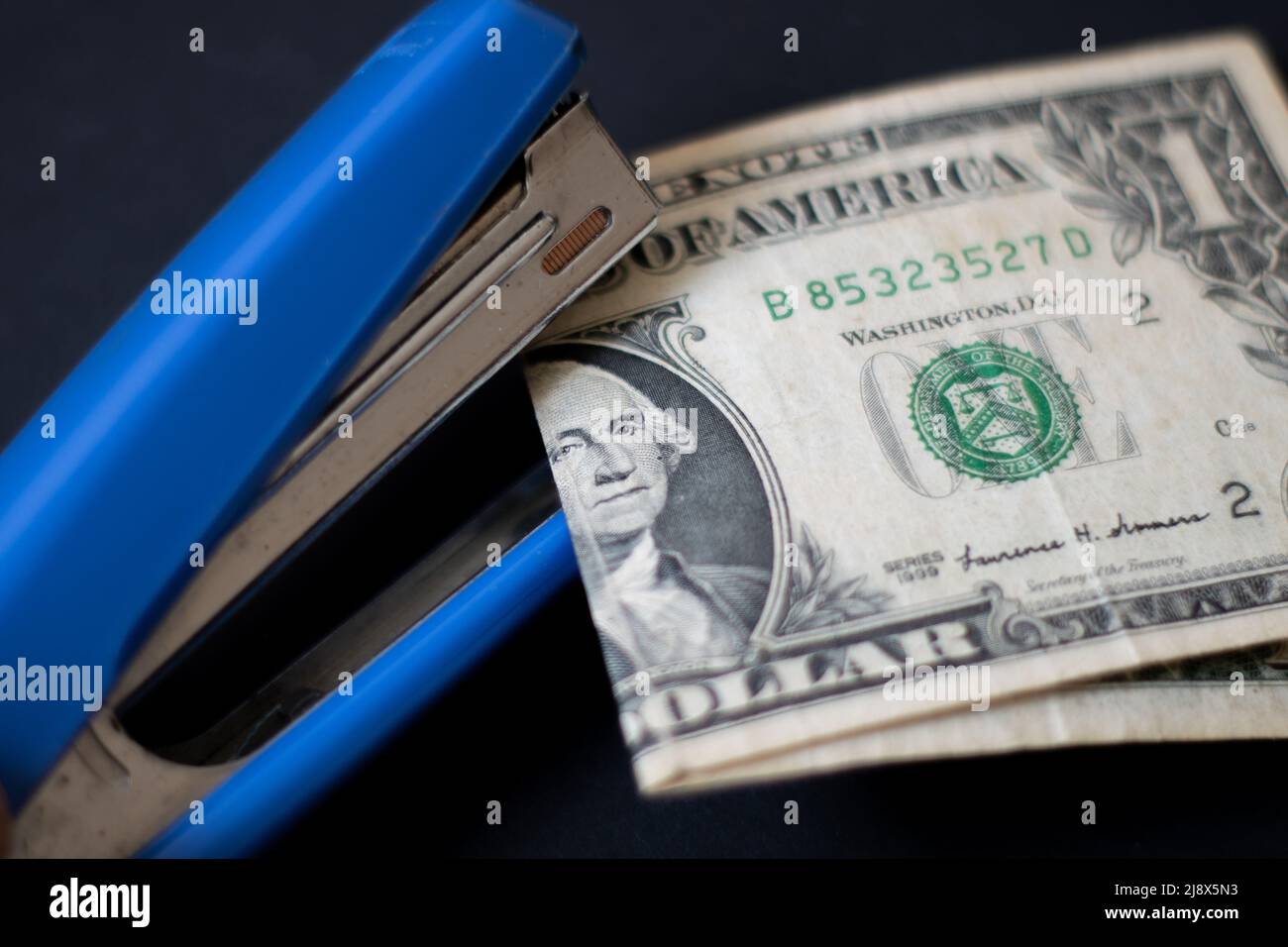 An effort to fix a worn-out dollar with a stapler Stock Photo