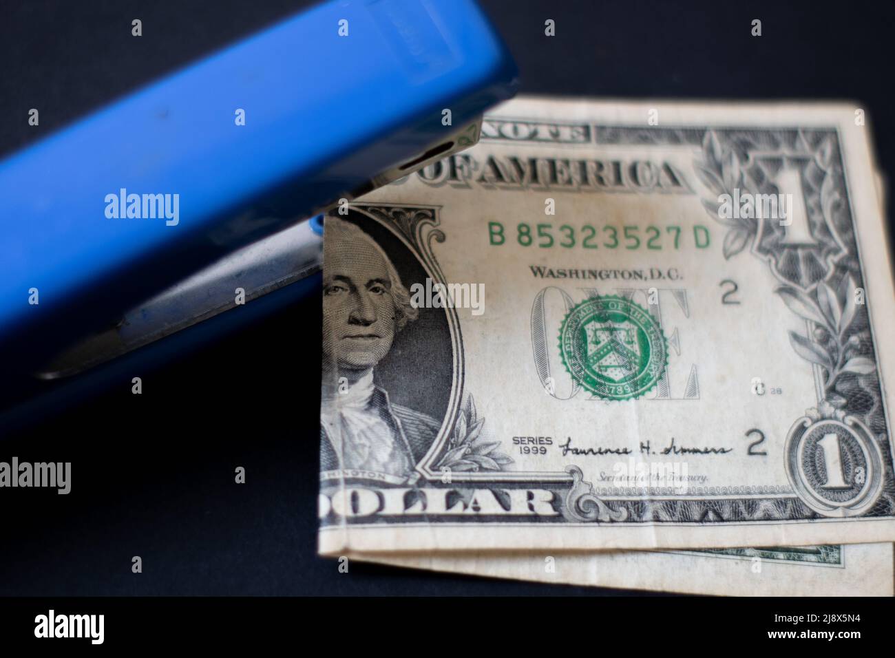 An effort to fix a worn-out dollar with a stapler Stock Photo