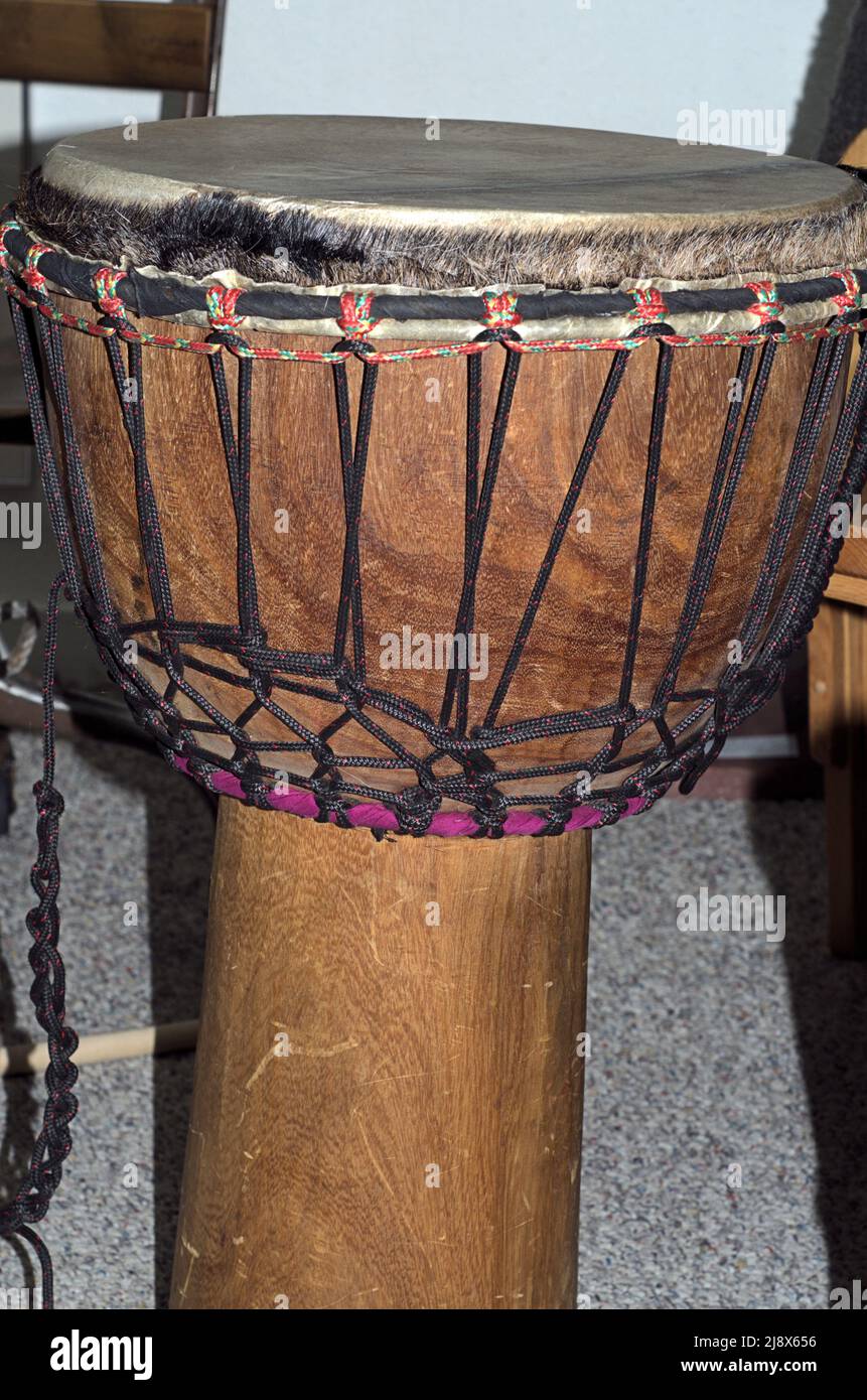 Tradional style drum with leather drumhead on a rounod post to be held with legs. Stock Photo