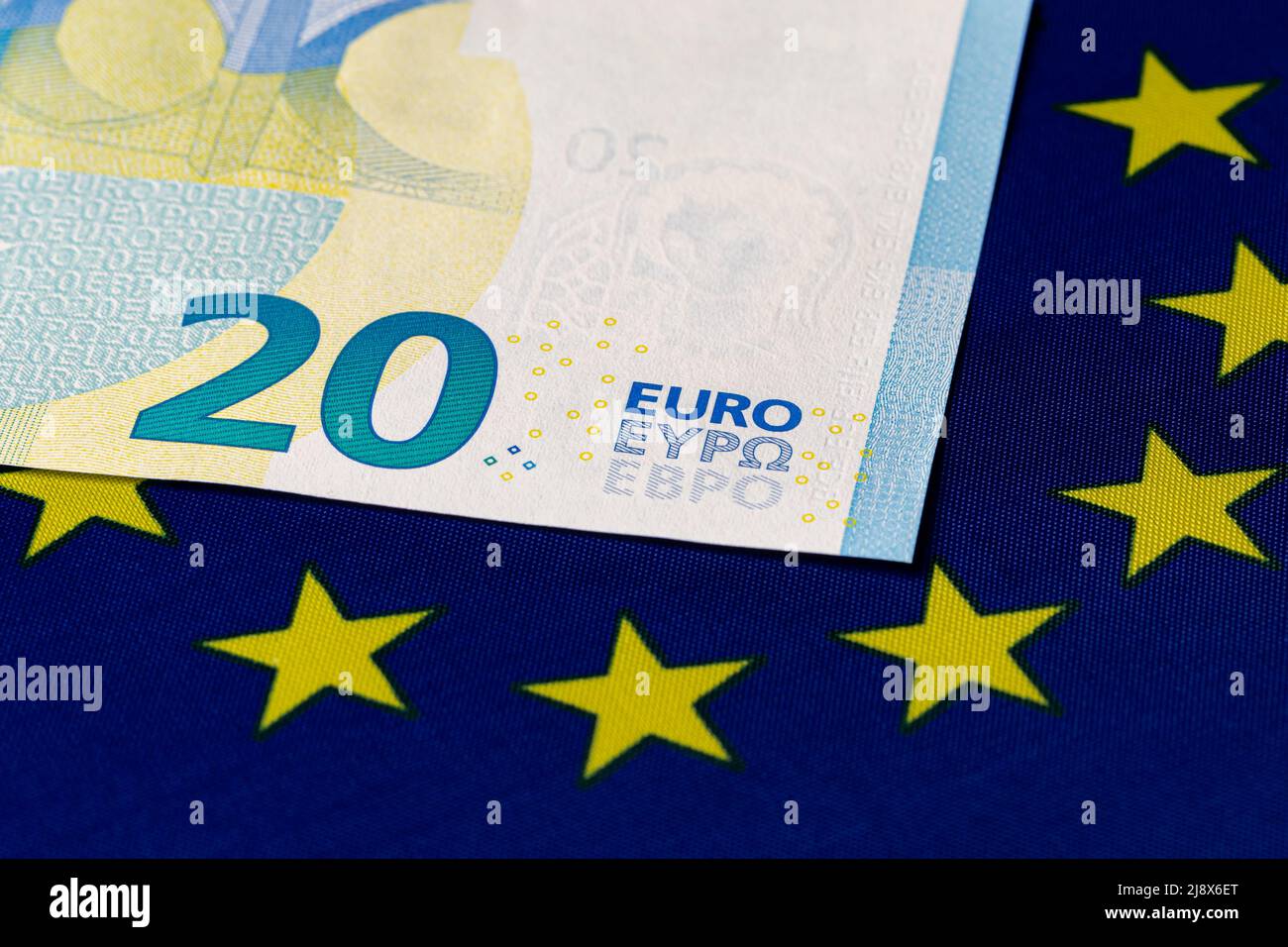 Euro banknote on European Union flag. Economy, financial and banking concept. Stock Photo