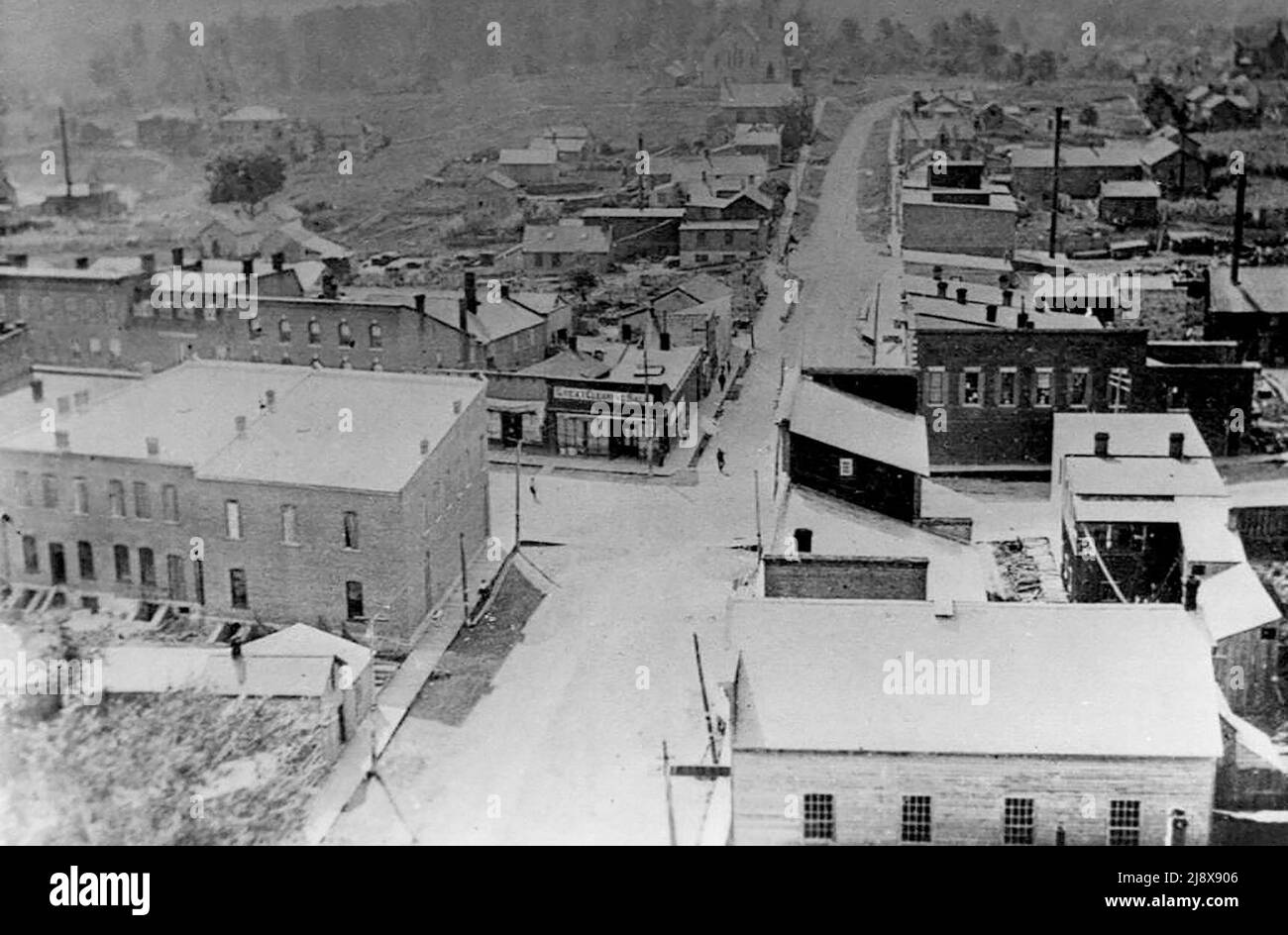 Photograph taken from the tower of the Methodist church shows the main intersection in Madoc Village, Ontario.  The view is looking west towards the Presbyterian church.  Bristol's Planning Mill is in the foreground on the right  ca.  1880 Stock Photo