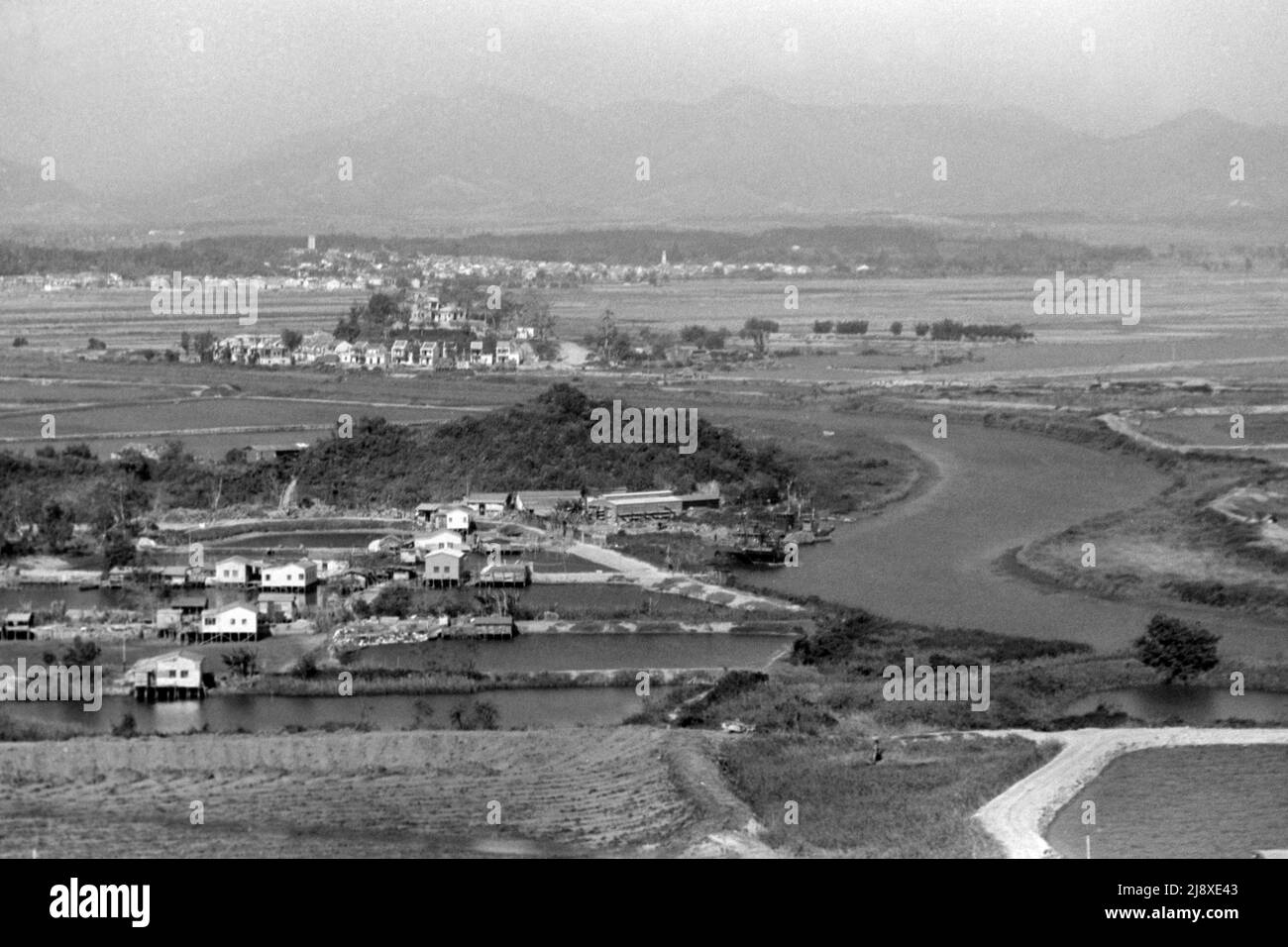 Black-and-white view of Ha Wan Village, from Lok Ma Chau Police Station, (Hong Kong) looking north with the Shenzhen River and Shenzhen, Guangdong, China, beyond. Date:  late 1979.  This is the site of the present Lok Ma Chau Border Crossing bridge (built 1989). Stock Photo