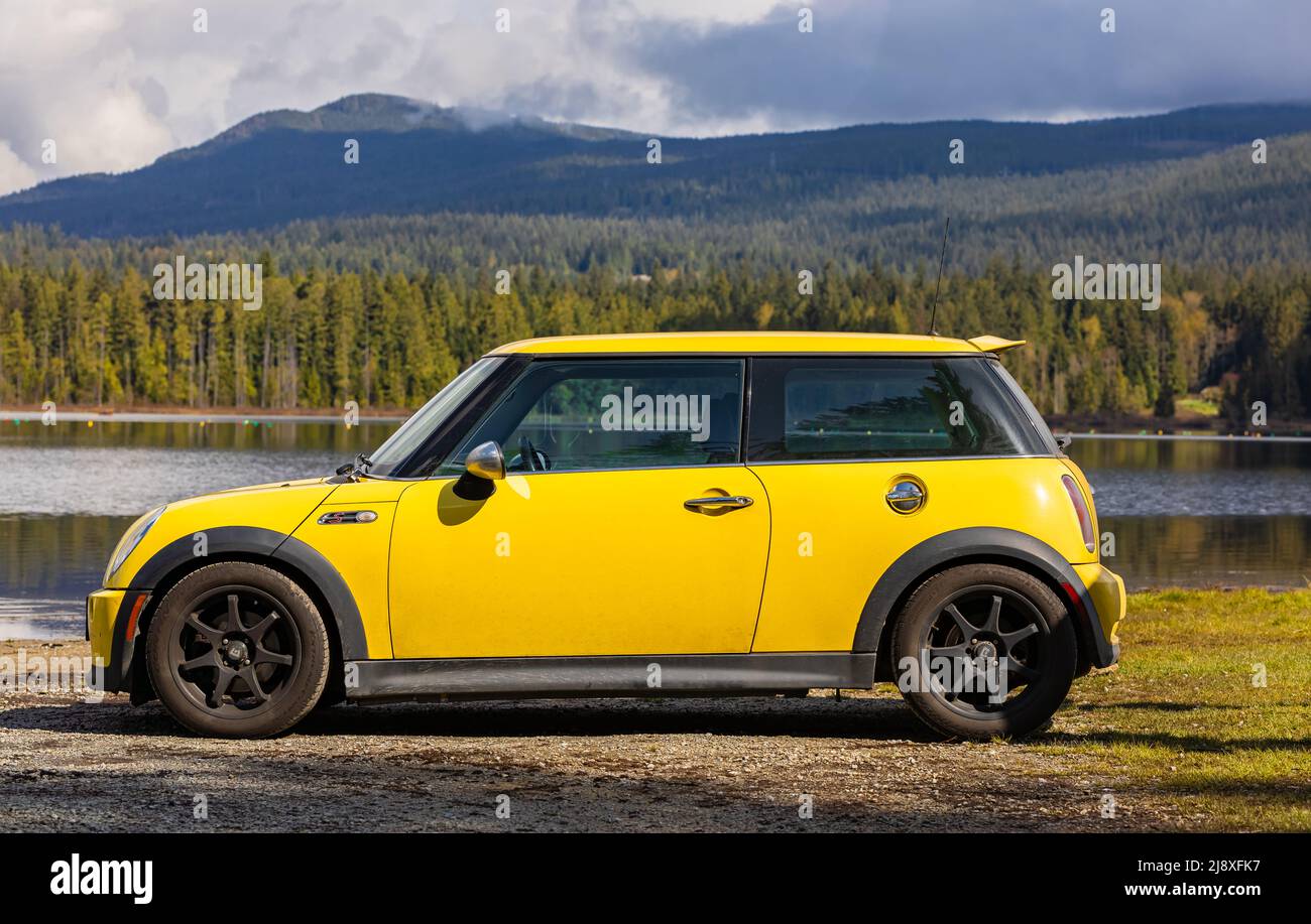 Side view of a Yellow Mini Cooper S car on natural background. Yellow