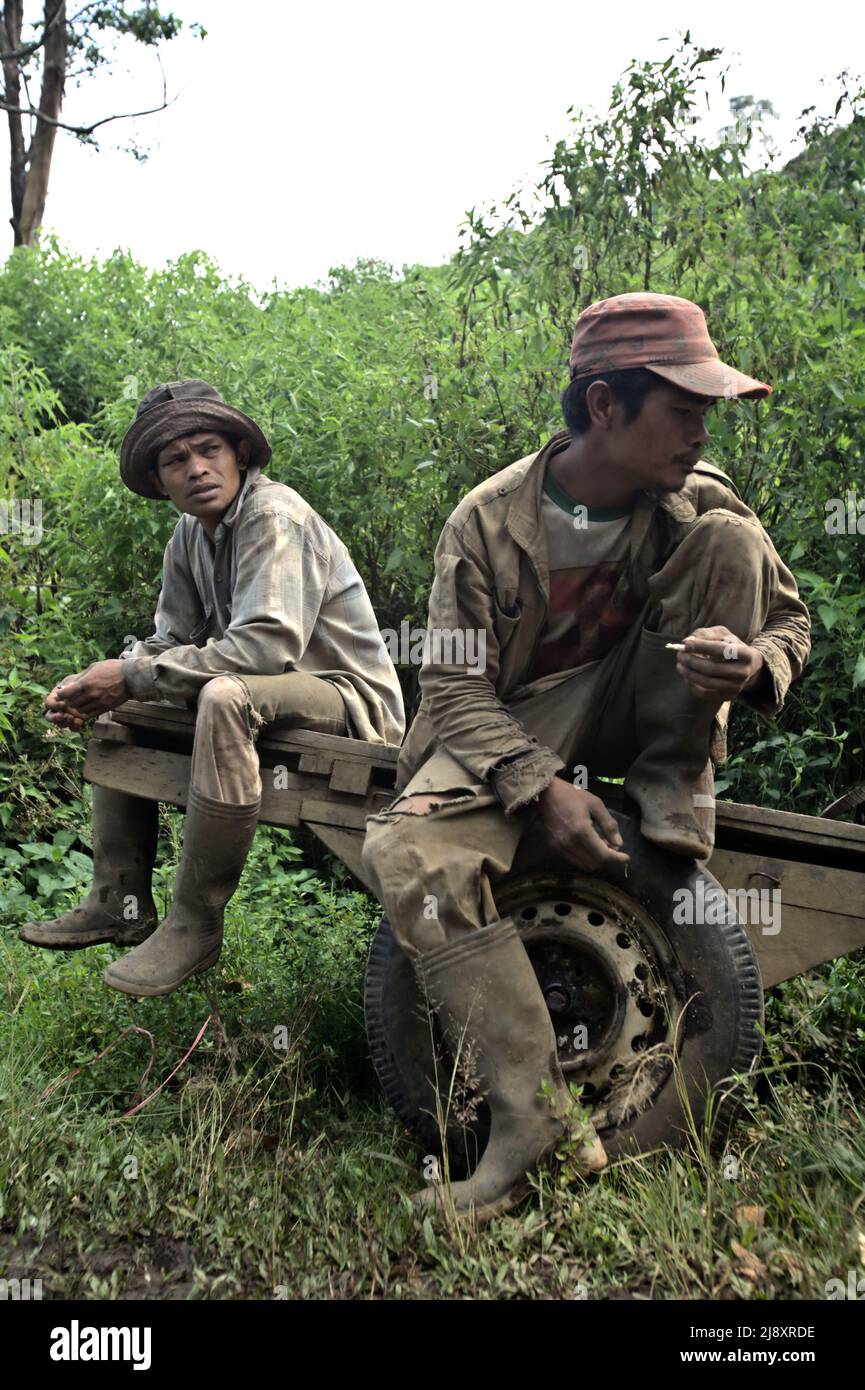 Portrait of agricultural workers sitting on a wooden cart in Gunung Tujuh, Kerinci, Jambi, Indonesia. Stock Photo